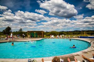 a large swimming pool with people in the water at Bend-Sunriver Camping Resort Studio Cabin 8 in Sunriver