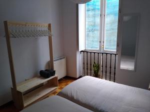 a bedroom with two beds and a window at A casa da Liberdade in Ourense