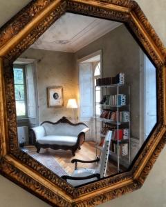 a mirror reflecting a room with a couch and a chair at Villa Ottocento in Campertogno