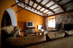 - un salon avec un canapé et une télévision dans l'établissement Casa Besana, à Camuñas