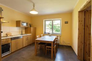 a kitchen with a wooden table and a window at Hügelhus in Kloster