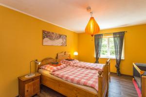 a bedroom with a bed with yellow walls at Hügelhus in Kloster