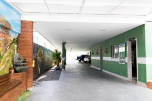un couloir vide dans un bâtiment orné de peintures sur les murs dans l'établissement Pousada Du Valle, à Embu