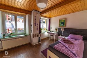 una camera da letto con un letto, un tavolo e finestre di Pension Chesselberg a Buckten