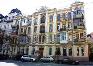 a large yellow building with cars parked in front of it at Kyiv Rouge Apartment in Kyiv