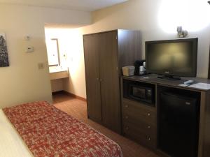 a hotel room with a television and a bed at MHO INN and SUITES in Monmouth Junction