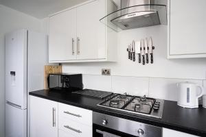 a kitchen with white cabinets and a stove top oven at Hopetoun House in Springside