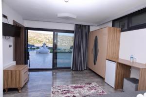 a living room with a large sliding glass door at FONTANA HOTEL FENER in Çeşme