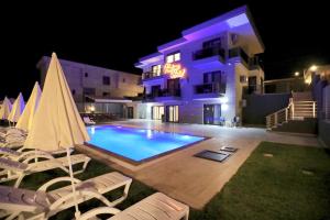 a swimming pool in front of a building at night at FONTANA HOTEL FENER in Çeşme