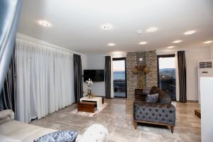 a living room with a couch and a tv at FONTANA HOTEL FENER in Çeşme