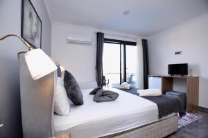 a bedroom with a bed with a lamp and a window at FONTANA HOTEL FENER in Çeşme