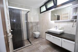 a bathroom with a shower and a sink and a toilet at FONTANA HOTEL FENER in Çeşme +18 photos