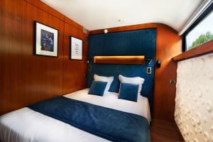 a bedroom with a bed with blue and white pillows at VIP Paris Yacht Hôtel & Spa in Paris +101 photos
