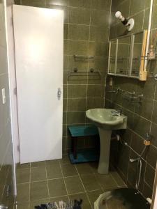 a small bathroom with a sink and a mirror at Castelo Veraneio in Guarujá