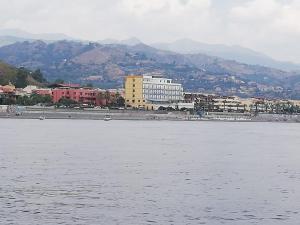 un grande bacino d'acqua con una città e edifici di Hotel Kennedy a SantʼAlessio Siculo