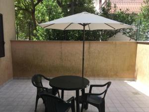 een zwarte tafel en stoelen met een paraplu bij Appartamento Gurrieri in Modica