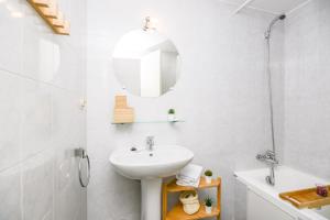 a white bathroom with a sink and a mirror at Apartamento Fontargent in Soldeu