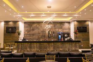 a lobby with a bar with a couch and chairs at Primar Plaza Hotel in Botucatu