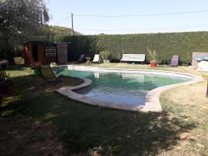 a swimming pool in a yard with a bench at Maison Tifaloc in Montélimar