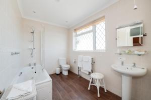 a bathroom with a sink and a tub and a toilet at The Coast Yard B & B and Garden Chalets in Selsey +37 photos