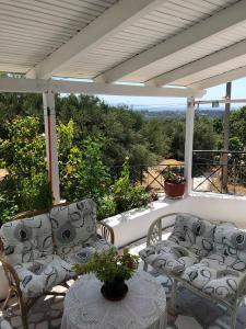 a porch with two chairs and a table with a view at SIAS HOUSE in Lixouri