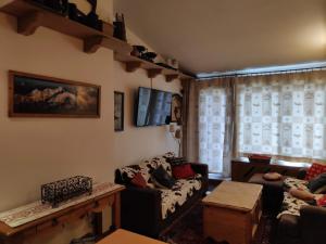 ein Wohnzimmer mit einem Sofa und einem Tisch in der Unterkunft Le Pramecou Tignes Val Claret in Tignes