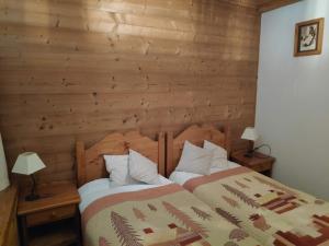 ein Schlafzimmer mit einem Bett mit einer Holzwand in der Unterkunft Le Pramecou Tignes Val Claret in Tignes