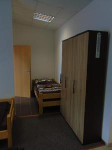 ストラコニツェにあるPenzion V Rájiのベッド1台とキャビネット付きの小さな部屋です。