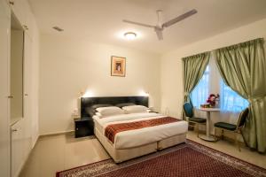 a bedroom with a bed and a table and a window at Hotel Summersands Al Wadi Al kabir in Muscat