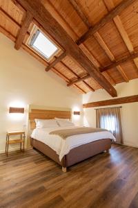 een slaapkamer met een groot bed in een kamer met houten plafonds bij AGRITURISMO LA CAMPAGNOLA in Montegaldella