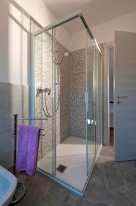 a glass shower in a bathroom with a purple towel at Casa Fellini in San Zeno di Montagna +25 photos