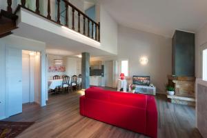 a living room with a red couch and a dining room at Casa Fellini in San Zeno di Montagna