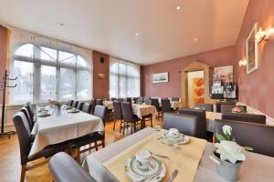een eetkamer met tafels en stoelen in een restaurant bij Hôtel Bar Des Vosges in Munster