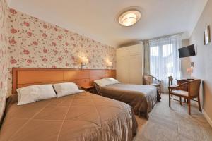 A bed or beds in a room at Hôtel Bar Des Vosges