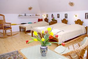 a bedroom with a bed and a vase of flowers on a table at Nádas Fogadó in Tiszadob