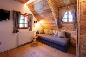salon z kanapą w pokoju z drewnianymi ścianami w obiekcie Das Holzpoidl w mieście Greisdorf