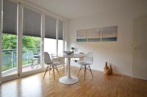 a white dining room with a table and chairs at Fair Apartment MAX 33 in Meerbusch
