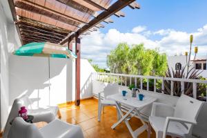 balcone con tavolo e sedie bianche. di The Colors House, 226 - Private Apartment a Costa Teguise
