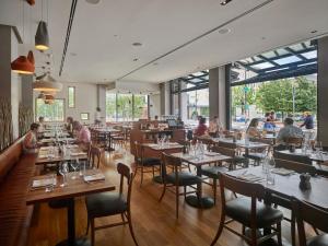 a restaurant with tables and chairs and people eating at The Study at University City, Study Hotels in Philadelphia