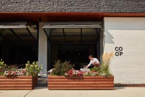 a man standing outside of a building with flowers at The Study at University City, Study Hotels in Philadelphia