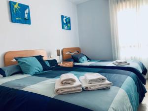 two beds with towels on them in a bedroom at Las Terrazas - Primera línea de playa con Netflix, Disney, Movistar con todo el fútbol, series, cine y Prime Video in Oropesa del Mar