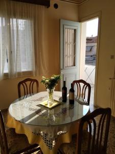 a dining room table with a vase of flowers on it at Paraskevi's House in Argos