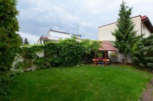 a house with a yard with a bench and a tree at Apartamenty Bałuty PARK in Łódź