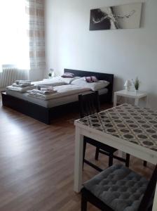 een woonkamer met twee bedden en een tafel en een tafel sidx sidx bij Apartment Alser in Wenen