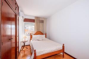 niewielka sypialnia z łóżkiem i oknem w obiekcie GuestRooms by HOA w Albufeirze