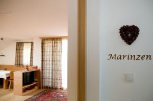 a living room with a kitchen and a living room with a heart on the wall at Wegmacherhof in Castelrotto