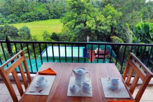 a wooden table with two chairs on a balcony at Villa 61 in Ambepussa