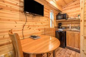 a dining room with a wooden table and a tv at Mount Hood Village Deluxe Cabin 5 in Welches