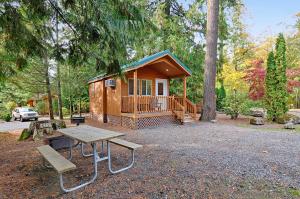 una piccola cabina con tavolo da picnic e panca di Mount Hood Village Deluxe Cabin 5 a Welches
