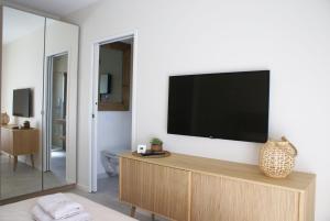 a living room with a flat screen tv on a wall at La maison du Potier in Valras-Plage